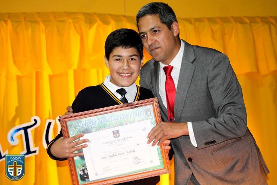Carlos Parada recibiendo su licencia y recuerdo junto a su profesor jefe.