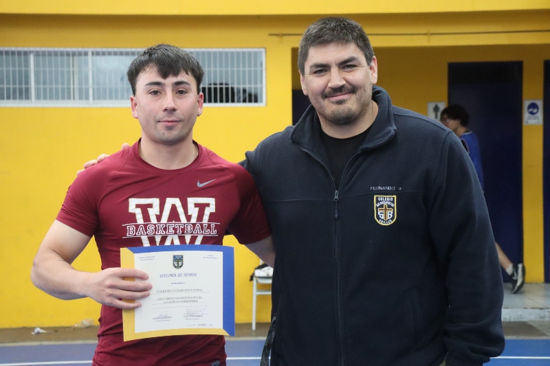 Profesor del Colegio Ciudad Educativa recibe diploma por la participación de su equipo.